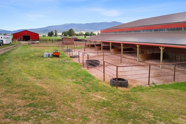 view of horse barn featuring a mountain view and a rural view