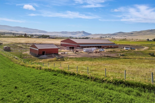 view of yard with an outdoor structure, a mountain view, and a rural view