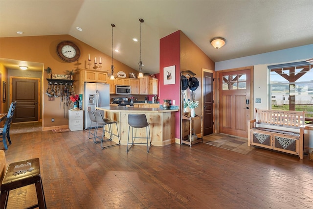 kitchen with a breakfast bar area, dark wood-type flooring, stainless steel appliances, and kitchen peninsula