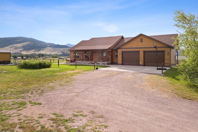 view of front facade with a mountain view, a garage, and a front lawn