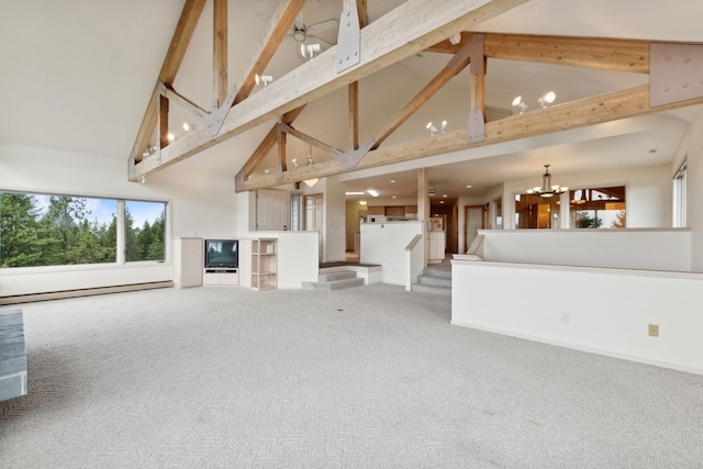 253 Pine Needle Ln, Bigfork, MT 59911 - unfurnished living room with high vaulted ceiling, carpet, a baseboard heating unit, beam ceiling, and a chandelier
