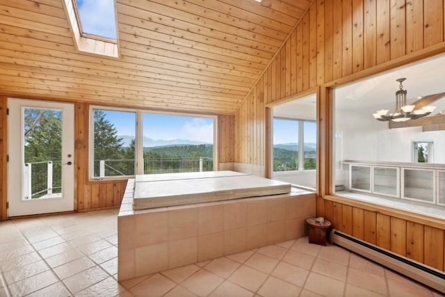 253 Pine Needle Ln, Bigfork, MT 59911 - unfurnished sunroom with a baseboard radiator, a mountain view, a chandelier, a skylight, and vaulted ceiling