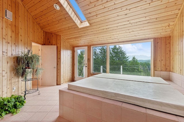 unfurnished sunroom featuring a wealth of natural light, lofted ceiling with skylight, a mountain view, and wooden ceiling