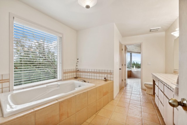 bathroom featuring visible vents, a garden tub, vanity, and toilet