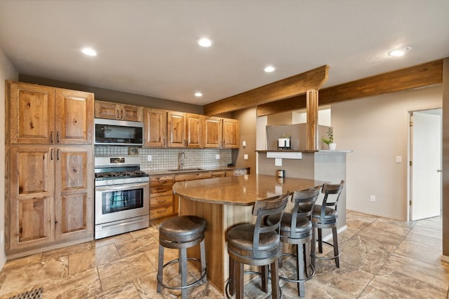 253 Pine Needle Ln, Bigfork, MT 59911 - kitchen featuring stainless steel appliances, a breakfast bar area, a peninsula, recessed lighting, and decorative backsplash