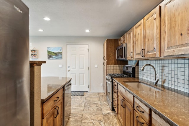 253 Pine Needle Ln, Bigfork, MT 59911 - kitchen featuring appliances with stainless steel finishes, dark stone counters, backsplash, recessed lighting, and brown cabinetry