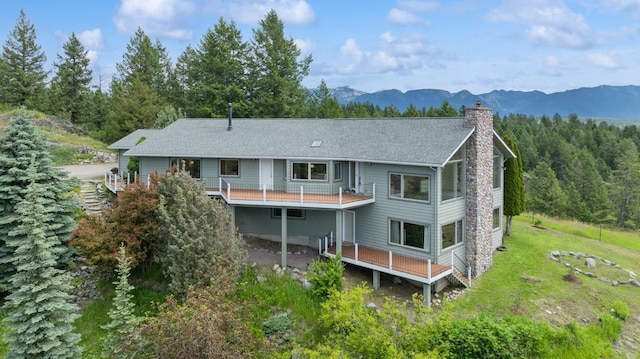 rear view of property featuring a deck with mountain view