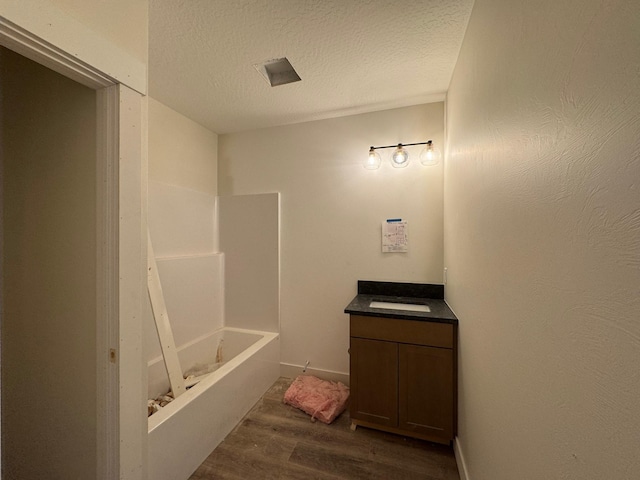 bathroom with vanity, hardwood / wood-style floors, a textured ceiling, and shower / bathing tub combination