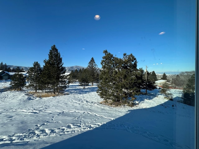 yard covered in snow featuring a mountain view