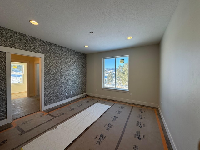 unfurnished room with a textured ceiling