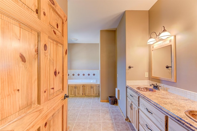 bathroom featuring vanity, a relaxing tiled tub, and tile patterned floors