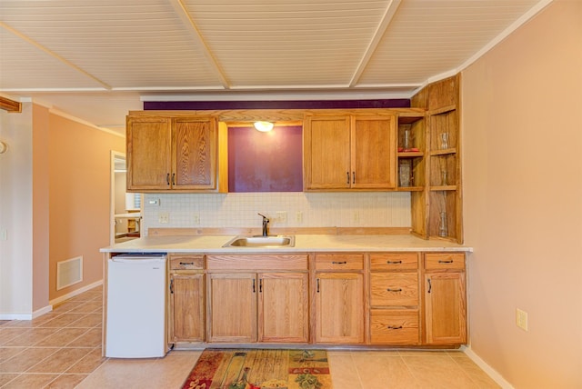 kitchen featuring tasteful backsplash, light tile patterned flooring, dishwasher, and sink