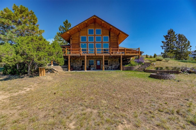 rear view of house with a lawn and a deck