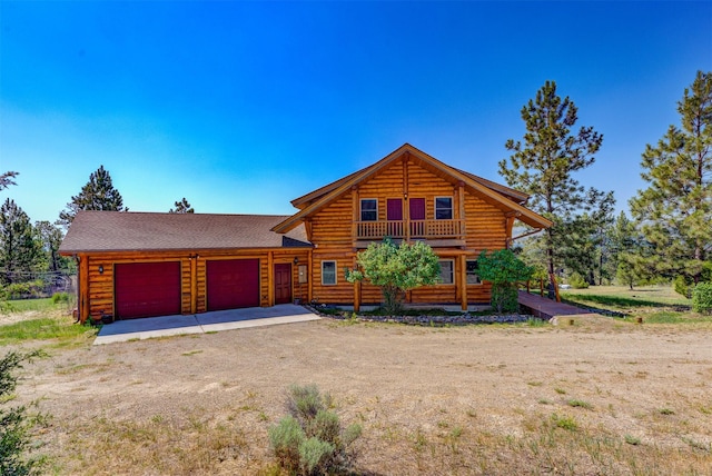 log home with a garage and a balcony