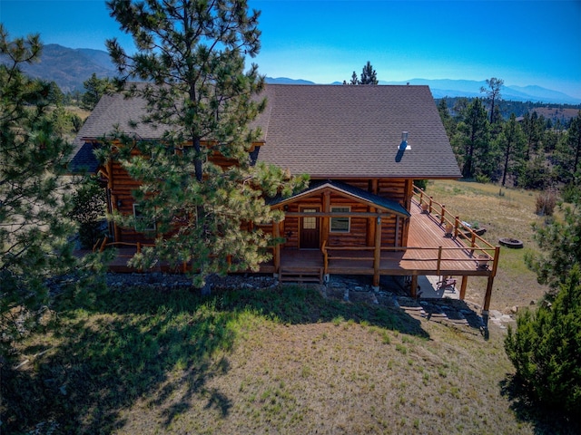 rear view of property with a yard and a deck with mountain view