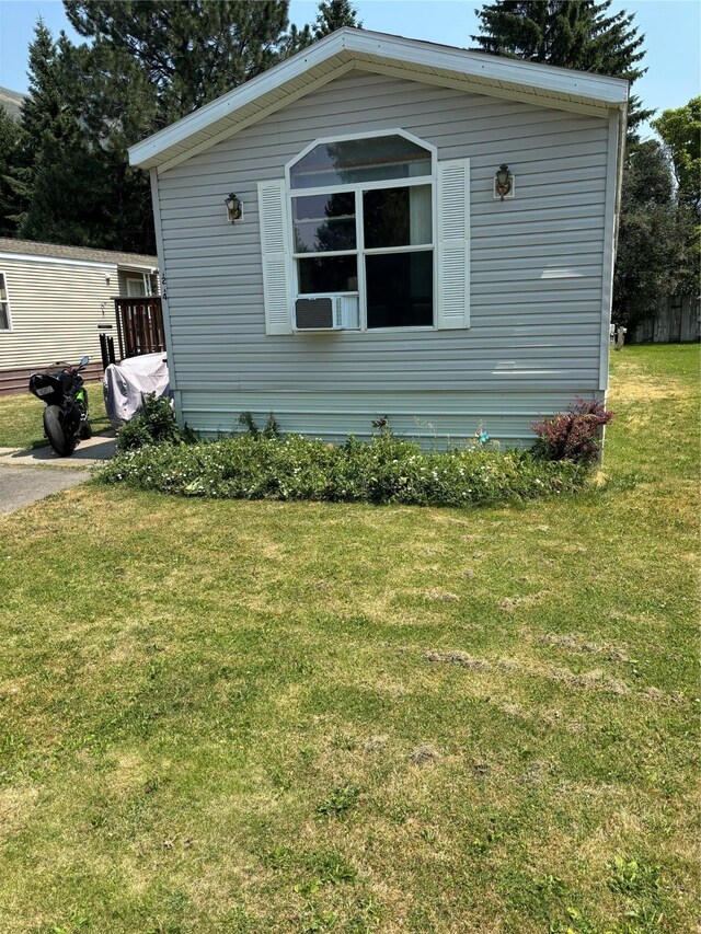 view of side of property with a yard and a wooden deck