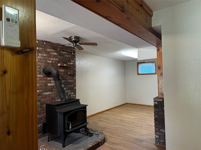 2378 Lake Creek Rd, Troy, MT 59935 - unfurnished living room with a wood stove, wood finished floors, baseboards, and a ceiling fan