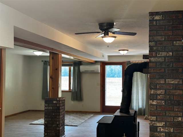 2378 Lake Creek Rd, Troy, MT 59935 - entryway featuring a wall mounted AC, wood finished floors, a ceiling fan, baseboards, and a wood stove