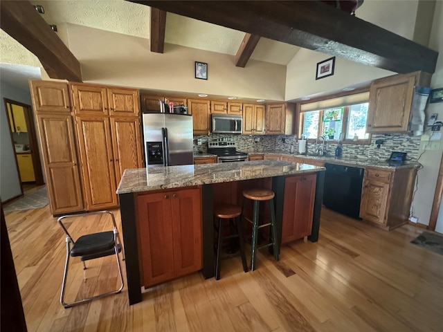 2378 Lake Creek Rd, Troy, MT 59935 - kitchen with stainless steel appliances, tasteful backsplash, beam ceiling, brown cabinetry, and light wood finished floors
