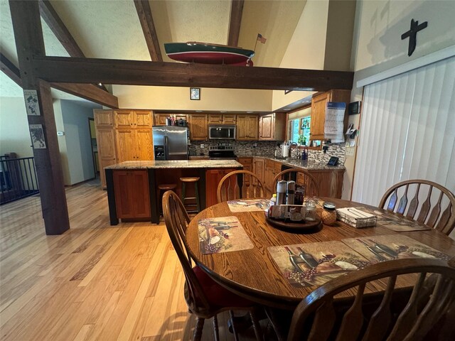 2378 Lake Creek Rd, Troy, MT 59935 - dining space featuring high vaulted ceiling, light wood-type flooring, and beamed ceiling