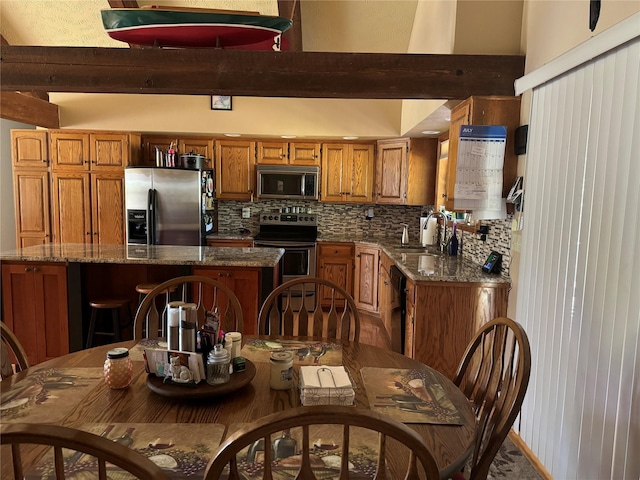 2378 Lake Creek Rd, Troy, MT 59935 - kitchen featuring stainless steel appliances, brown cabinetry, a sink, and tasteful backsplash