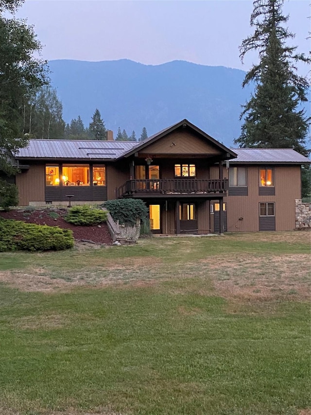 2378 Lake Creek Rd, Troy, MT 59935 - back of house at dusk with a lawn, metal roof, and a chimney