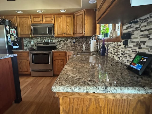 2378 Lake Creek Rd, Troy, MT 59935 - kitchen with appliances with stainless steel finishes, a sink, backsplash, brown cabinetry, and recessed lighting