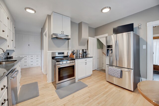 kitchen featuring sink, light wood-type flooring, stainless steel appliances, and white cabinets