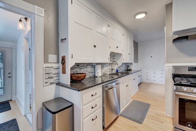 kitchen featuring sink, appliances with stainless steel finishes, white cabinets, and backsplash