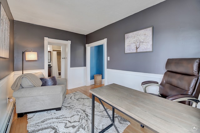 office area featuring a baseboard radiator and light hardwood / wood-style flooring