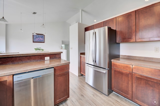 kitchen featuring pendant lighting, stainless steel appliances, lofted ceiling, and light wood-type flooring