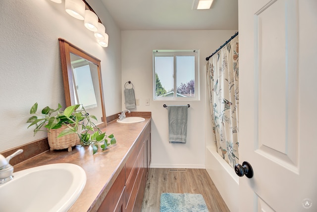 bathroom featuring hardwood / wood-style flooring, shower / bath combination with curtain, and vanity