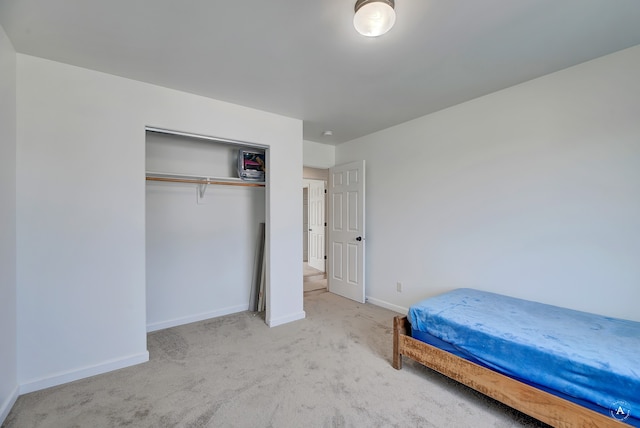 unfurnished bedroom featuring light colored carpet and a closet