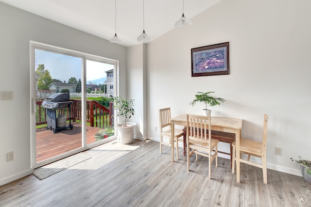 dining room with lofted ceiling and light wood-type flooring