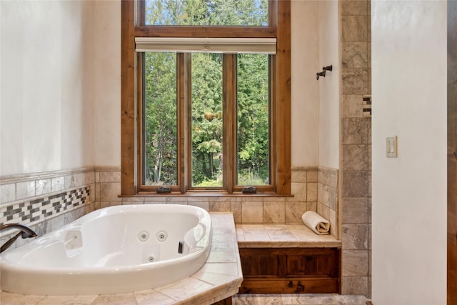 bathroom featuring a wealth of natural light and a jetted tub