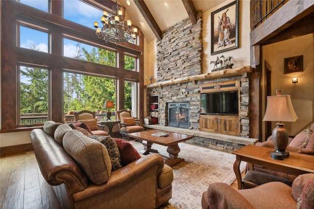 living room featuring beam ceiling, a fireplace, a high ceiling, a chandelier, and hardwood / wood-style floors