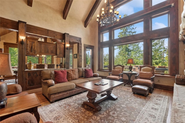 living area with a healthy amount of sunlight, a notable chandelier, beamed ceiling, and wood finished floors