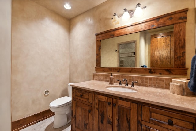 bathroom with toilet, vanity, and decorative backsplash