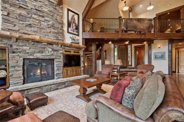 living room with high vaulted ceiling and a stone fireplace