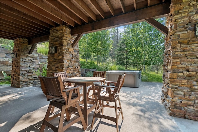 view of patio / terrace featuring outdoor dining area and a hot tub