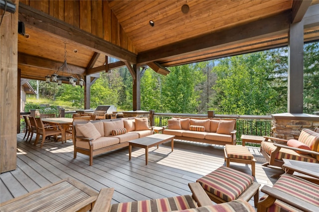 deck with outdoor dining space, a grill, and an outdoor hangout area