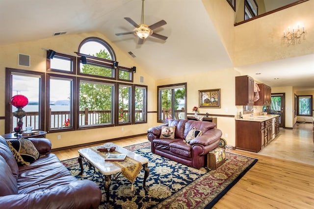 living room with high vaulted ceiling, sink, ceiling fan, and light tile patterned floors