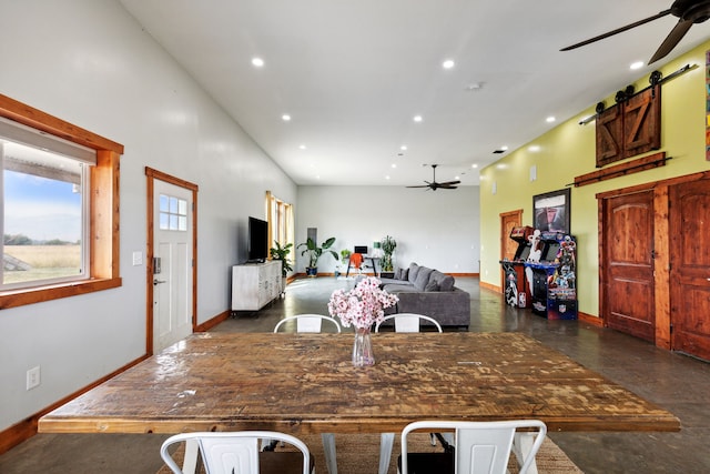 dining area featuring ceiling fan and a barn door