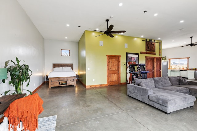 living room with ceiling fan, a barn door, concrete flooring, and a high ceiling