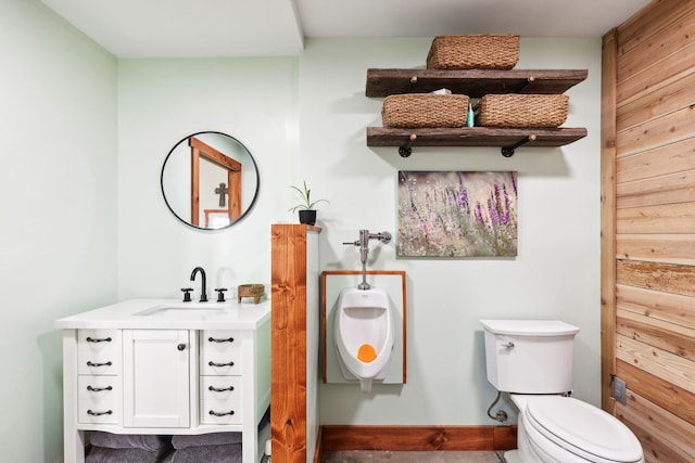 bathroom featuring vanity, toilet, and wooden walls