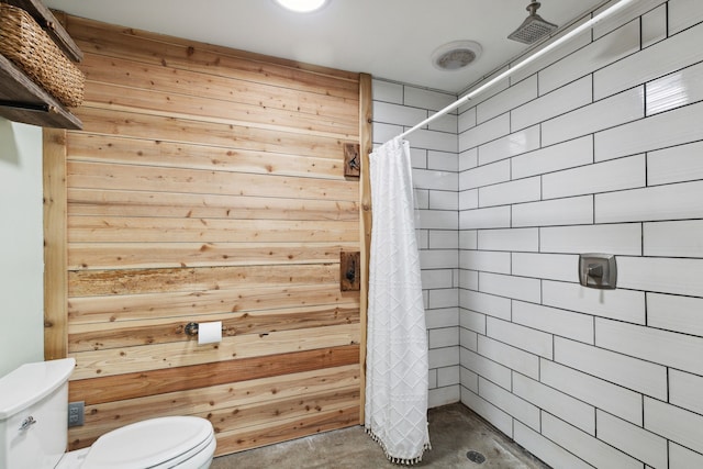 bathroom featuring wooden walls, toilet, concrete floors, and walk in shower