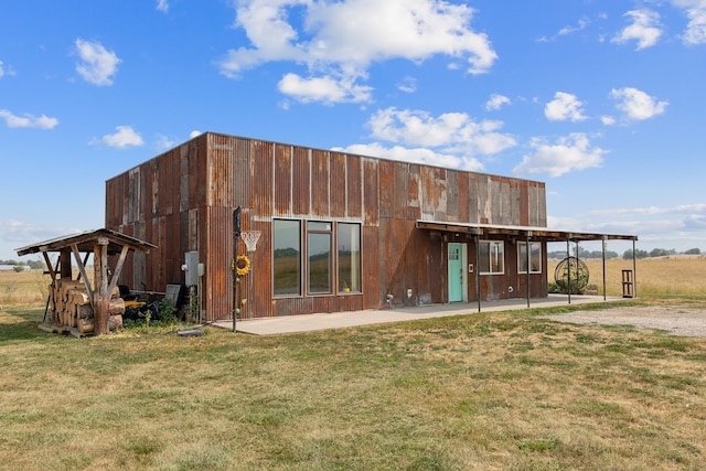 rear view of property with a lawn and an outdoor structure