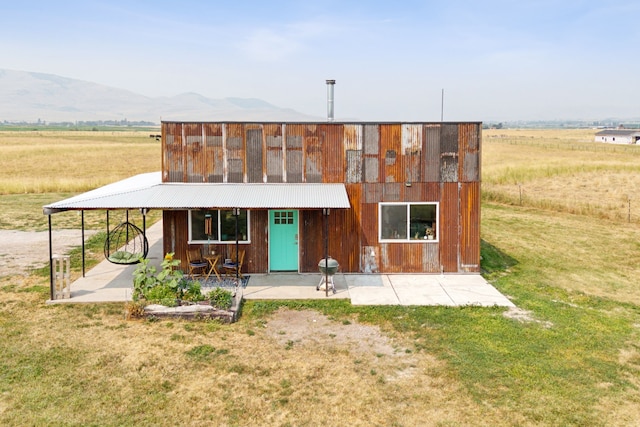 back of house featuring a mountain view and a rural view