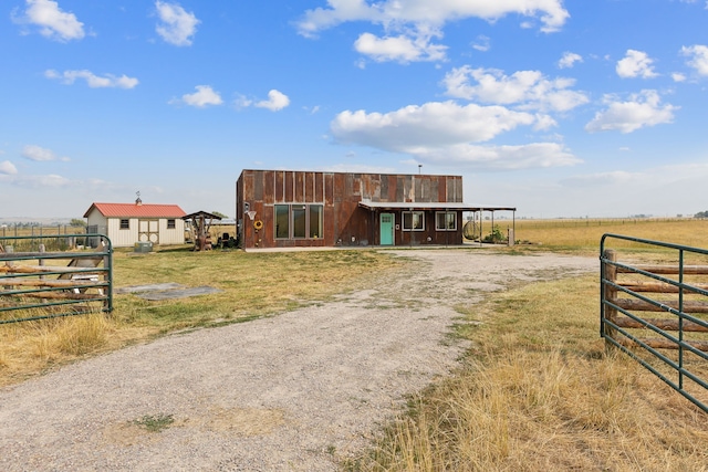 view of front of property featuring a rural view and an outbuilding