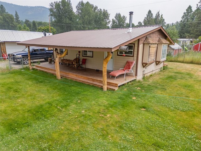 back of house with a yard and a deck with mountain view